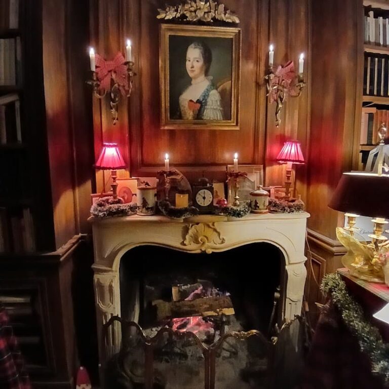 Cheminée du salon décorée pour Noël, sous le portrait d’une dame