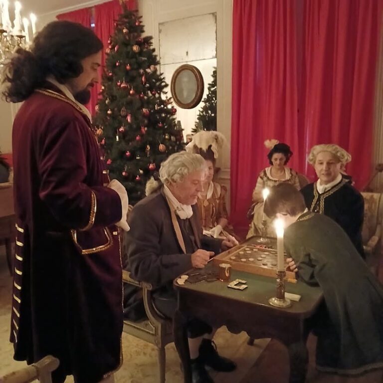Joueurs de cartes costumés autour d’une table, à la bougie