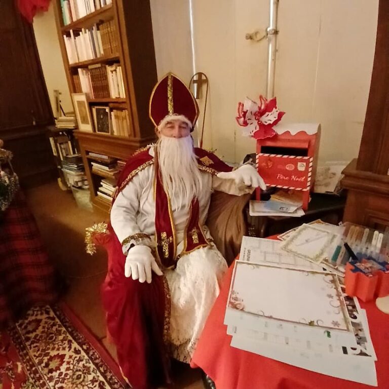 Saint Nicolas à son bureau, près de la boîte aux lettres du Père Noël