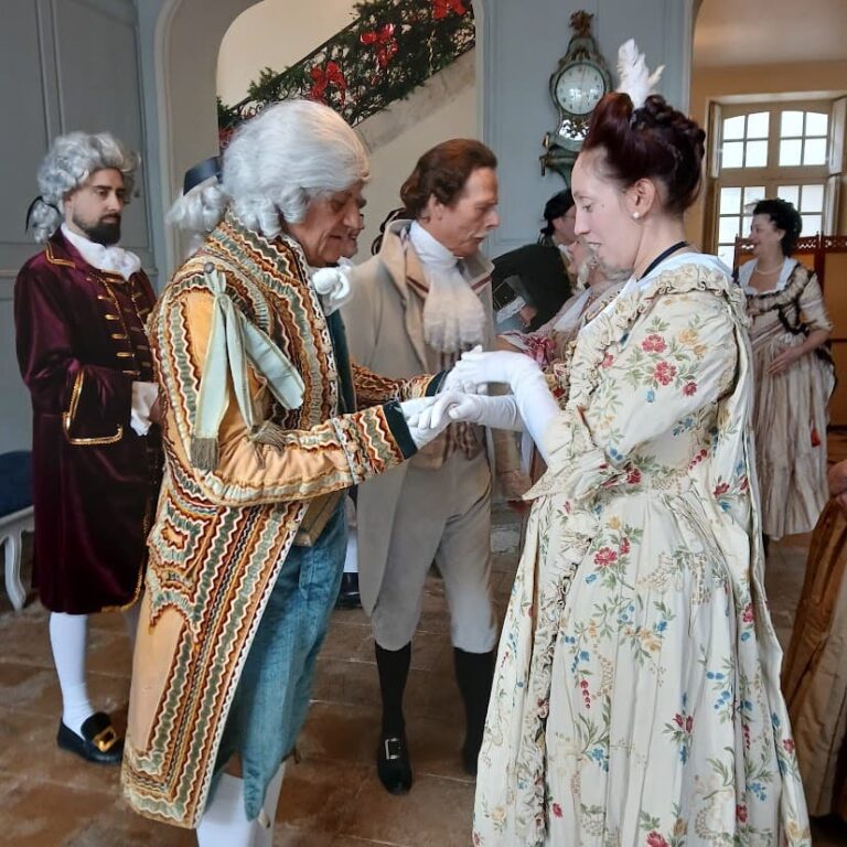 Figurants en costume du XVIIIe siècle dans le hall, devant l’escalier décoré