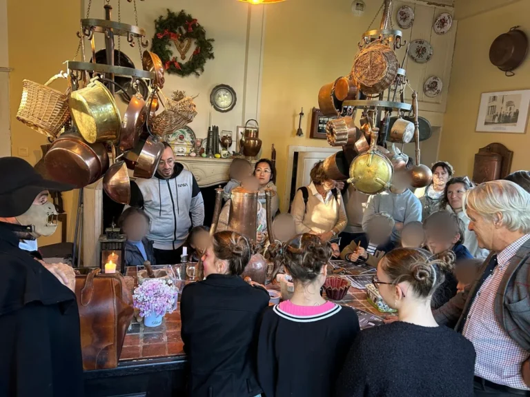 Les enfants autour de la table, entourés de casseroles en cuivre, visages floutés