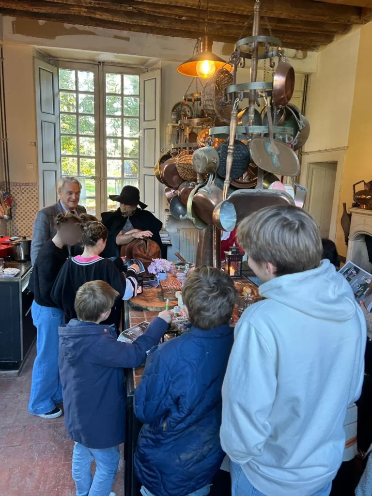 Enfants à l'écoute devant la grande table de la cuisine, visages floutés
