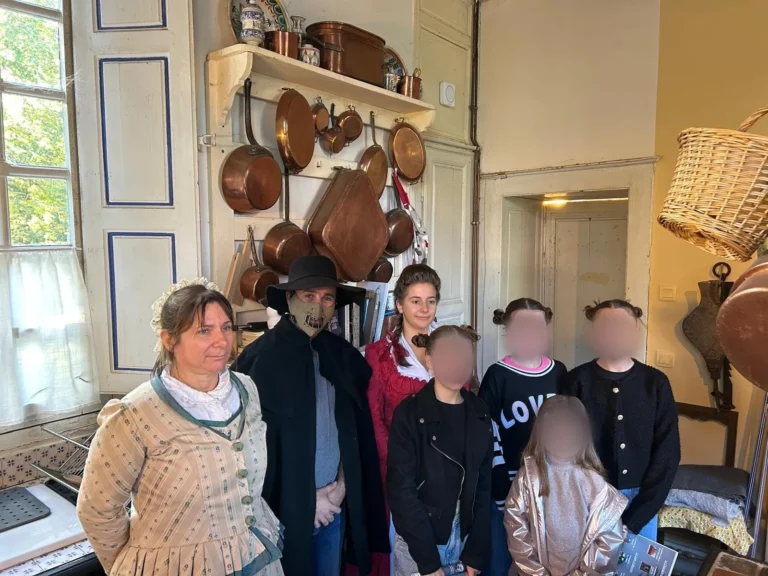 Groupe d'enfants posant avec deux figurants costumés dans la cuisine, visages floutés