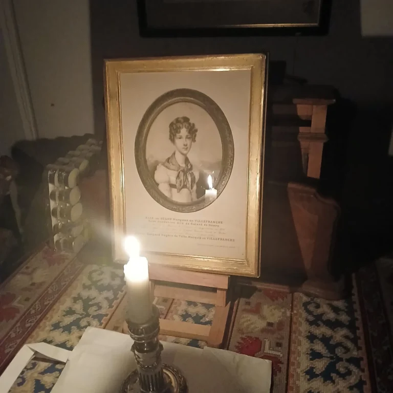 Portrait gravé dans un cadre, éclairé par une bougie